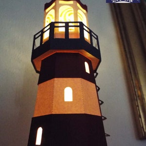 May include: A papercraft lighthouse model with a black and brown striped exterior. The lighthouse has a small balcony and a light at the top. The light is on and illuminating the interior of the lighthouse.