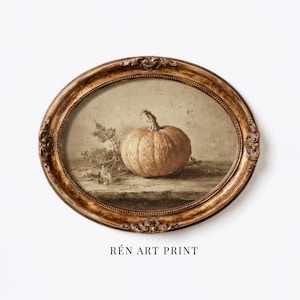 May include: An oval-shaped, ornate gold-toned frame containing an art print of a single pumpkin with stems and leaves. The artwork features a muted, sepia-toned color palette with a textured appearance. The text REN ART PRINT is below the frame.
