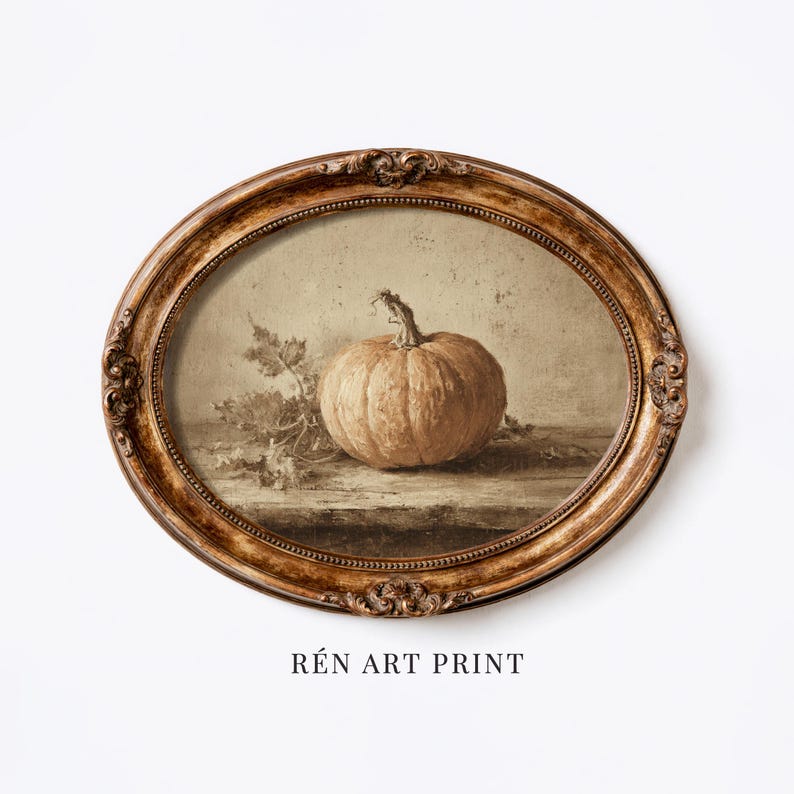 May include: An oval-shaped, ornate gold-toned frame containing an art print of a single pumpkin with stems and leaves. The artwork features a muted, sepia-toned color palette with a textured appearance. The text REN ART PRINT is below the frame.