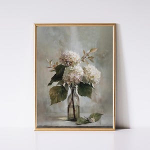 May include: A framed art print featuring a still life of white hydrangea flowers in a clear glass bottle. The artwork has a soft, muted color palette with green leaves and a gold frame. The painting evokes a vintage, botanical theme.