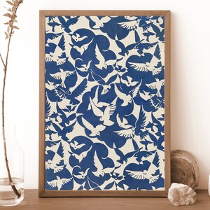 K&ouml;nnte beinhalten: Ein gerahmter Druck mit wei&szlig;em Hintergrund und einem sich wiederholenden Muster aus blauen Tauben. Die Tauben sind in verschiedenen Positionen angeordnet und erzeugen ein dynamisches und abstraktes Design.
