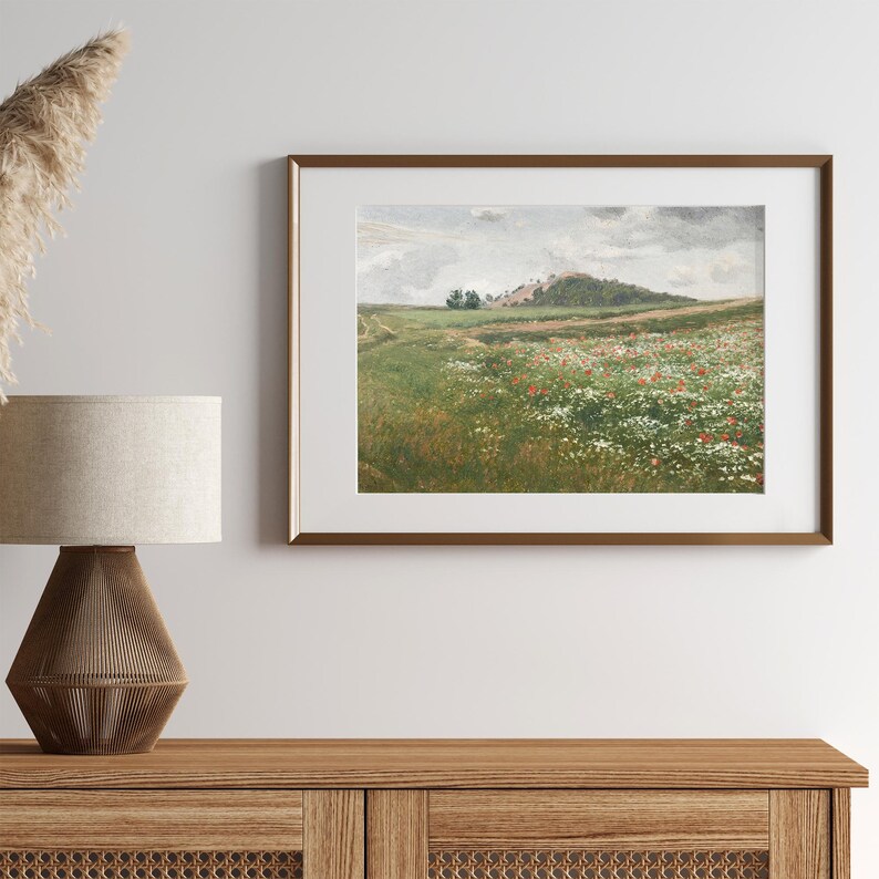 May include: A framed painting of a landscape with a hill in the distance, a field of wildflowers, and a cloudy sky.