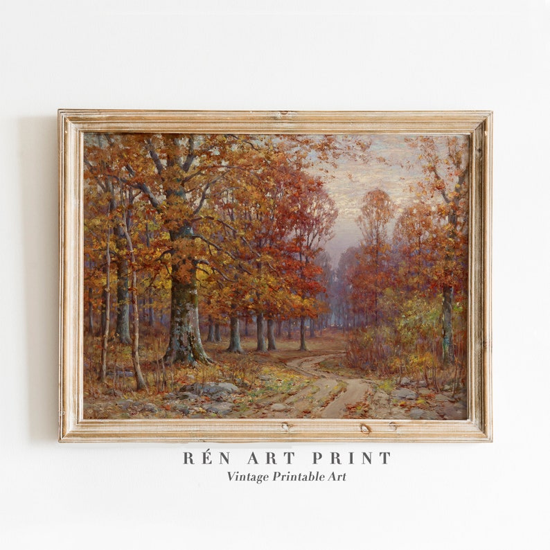 May include: A framed vintage art print of a forest scene in autumn. The painting features a dirt path winding through trees with vibrant orange and red leaves. The frame is a light gold color. The text "R&Eacute;N ART PRINT Vintage Printable Art" is at the bottom.
