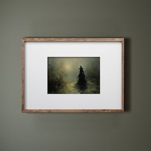May include: A framed art print depicts a silhouetted figure in a witch's hat and flowing gown wading through water. The artwork is set in a misty, atmospheric landscape with muted greens and browns, and a soft, golden light.
