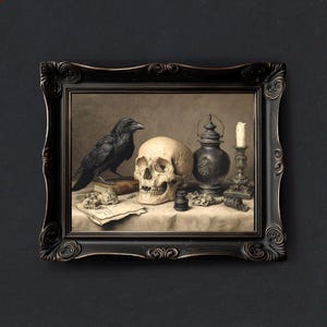 May include: A framed still life painting featuring a black raven, a human skull, a vintage lantern, a candle, and a book. The artwork has a dark, gothic aesthetic, with a black ornate frame and a neutral background.