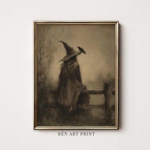 Op de afbeelding: Een ingelijste kunstdruk in een goudkleurige lijst met een sepia-illustratie van een figuur met een puntmuts die op een houten hek zit met een vogel op de rand. De tekst RÉN ART PRINT is zichtbaar aan de onderkant van de lijst.