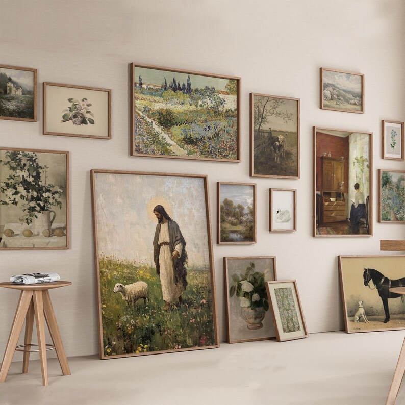 May include: A collection of framed art prints in various sizes and styles, including landscapes, floral arrangements, and religious figures. The frames are a light brown color, and the artwork features a vintage aesthetic.
