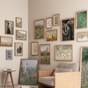 May include: A collection of framed vintage art prints in various sizes and styles, including landscapes, portraits, and floral designs. The frames are a warm wood tone, and the artwork features soft colors and classic imagery. The arrangement creates a gallery wall aesthetic.