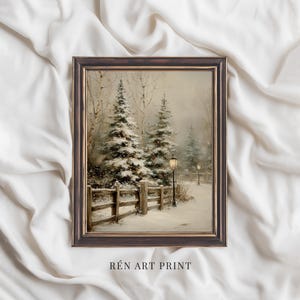 May include: A framed art print showing a winter landscape with snow-covered fir trees, a wooden fence, and lampposts. The artwork has a vintage style with a muted colour palette. The text "RÉN ART PRINT" is at the bottom.
