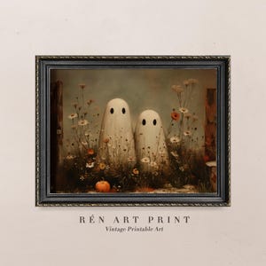 May include: A framed vintage art print featuring two white ghost figures with black eyes standing in a field of wildflowers and a small pumpkin. The artwork has a dark frame and the text "R&eacute;n Art Print Vintage Printable Art" at the bottom.