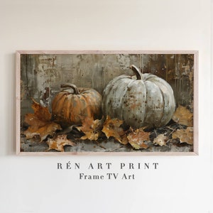 Puede incluir: Una pintura enmarcada de dos calabazas, una naranja y otra verde, con hojas de oto&ntilde;o esparcidas a su alrededor. La pintura tiene un fondo r&uacute;stico y texturizado y se titula "R&Eacute;N ART PRINT Frame TV Art".