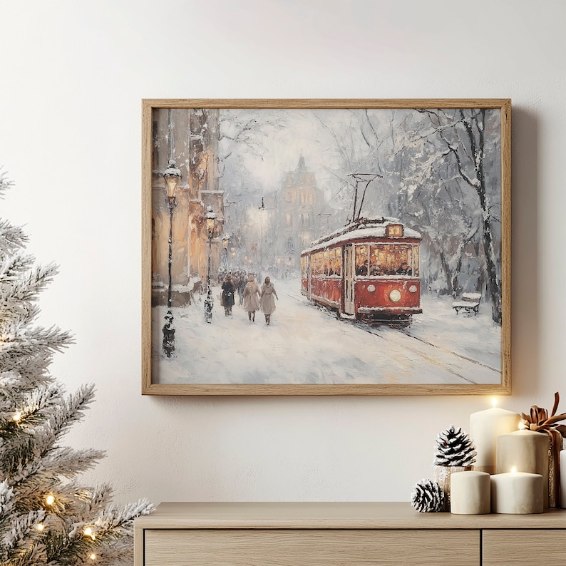 May include: A framed winter landscape painting depicts a red trolley car on a snow-covered street. People walk along the sidewalk, and the scene is illuminated by streetlights. The artwork is in a wooden frame.