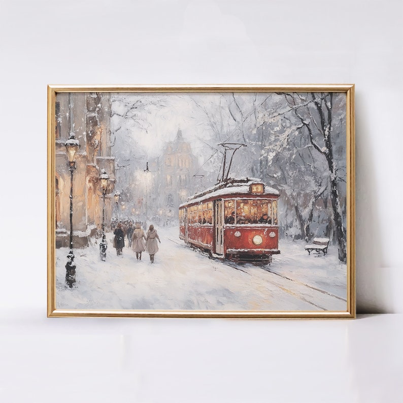 May include: Framed art print of a winter scene. A red trolley car travels down a snow-covered street lined with buildings and trees. Figures walk along the sidewalk. The artwork is in a gold frame.