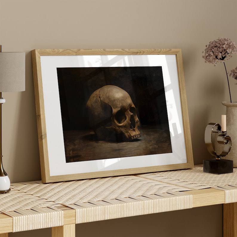 May include: A framed print of a black and white still life featuring a human skull on a dark background.