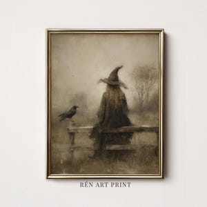May include: A framed art print in a gold frame depicting a figure wearing a pointed hat and long cloak sitting on a wooden fence in a misty landscape with a black crow perched nearby. The text RÉN ART PRINT is visible at the bottom of the image.