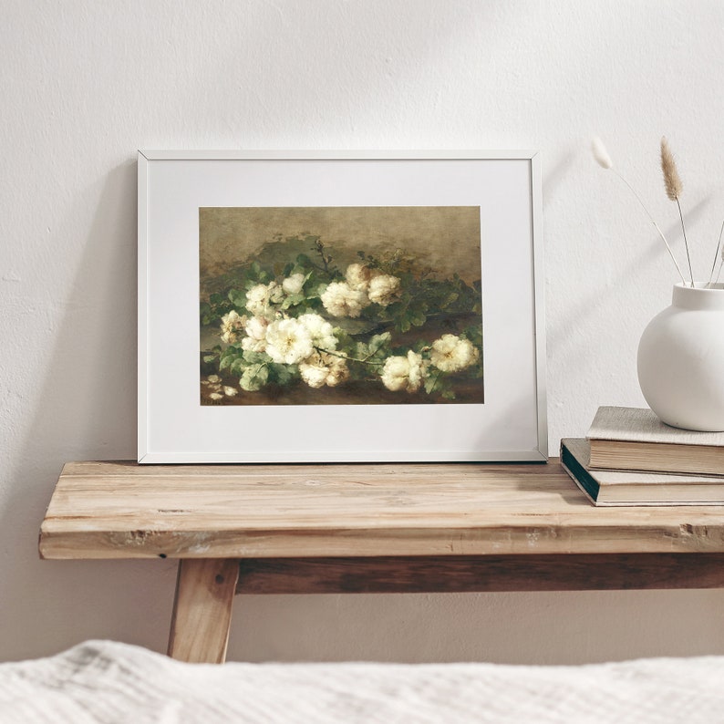 May include: A framed painting of a bouquet of white roses with green leaves on a brown background.