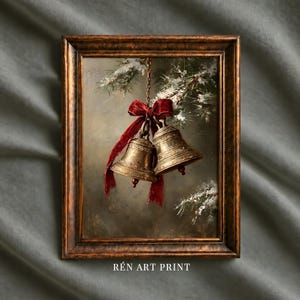 Può includere: Una stampa artistica incorniciata raffigurante due campane dorate appese a un ramo di pino innevato, legate insieme da un nastro di velluto rosso scuro. L'opera è racchiusa in una cornice di legno scuro e decorata con il testo REN ART PRINT.