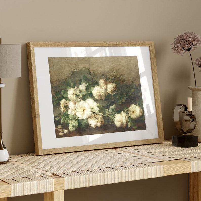 May include: A framed painting of a bouquet of white roses with green leaves on a brown background.