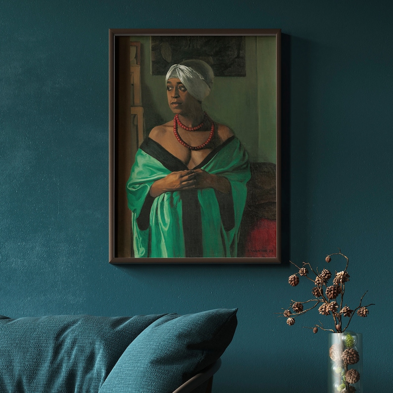 Puede incluir: Un retrato enmarcado de una persona con un pa&ntilde;uelo blanco en la cabeza, un collar de cuentas rojo y una t&uacute;nica verde y negra. La pintura se exhibe en una pared verde azulado sobre un sof&aacute; verde azulado. Un jarr&oacute;n con ramas decorativas est&aacute; en primer plano.