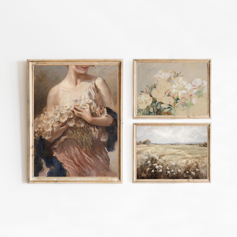 Op de afbeelding: Drie ingelijste schilderijen met een vintage esthetiek. Het linker schilderij toont een vrouw in een roze jurk die een boeket witte bloemen vasthoudt. Het middelste schilderij toont een boeket witte bloemen. Het rechter schilderij toont een veld met witte bloemen.