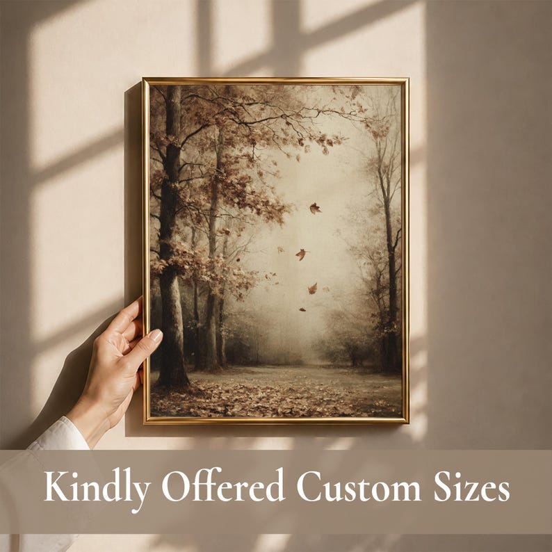 May include: A rectangular wall art print in a thin gold frame featuring a sepia-toned forest scene with bare trees, fallen leaves on the ground, and several leaves drifting through the air. The artwork displays a muted, earthy color palette.