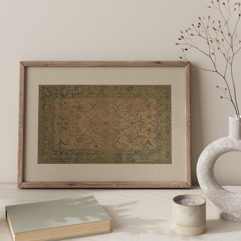 May include: A rectangular framed print featuring a vintage-style rug pattern with a central tan field, intricate floral motifs in muted blue and green, and a wide decorative border, all encased in a light-toned wooden frame with a beige mat.
