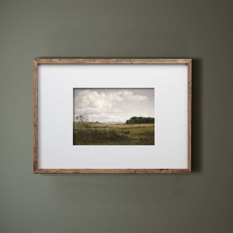Pode incluir: Uma pintura de paisagem emoldurada com um campo, &aacute;rvores e um c&eacute;u nublado. A obra de arte est&aacute; emoldurada em uma moldura de madeira marrom clara r&uacute;stica e uma montagem branca. A pintura retrata uma cena externa serena.