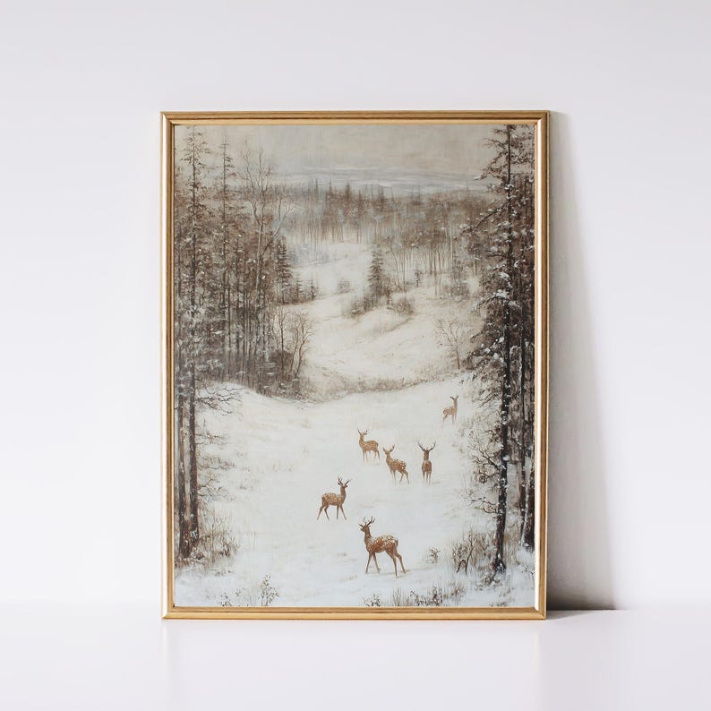 Op de afbeelding: Een ingelijste vintage prent toont een winterlandschap met herten. Het kunstwerk toont een besneeuwde sc&egrave;ne met bomen en verschillende herten in een gouden lijst. Het kleurenpalet omvat tinten bruin, wit en grijs.