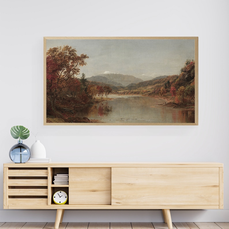 Puede incluir: Una pintura de paisaje enmarcada que representa un r&iacute;o que fluye a trav&eacute;s de un valle con monta&ntilde;as en el fondo. Los &aacute;rboles est&aacute;n en colores oto&ntilde;ales, con tonos de rojo, naranja y amarillo.