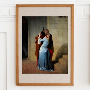 May include: A painting of a couple embracing and kissing in a stone hallway. The man is wearing a brown coat and a hat, while the woman is wearing a blue dress. The painting is set in a historical period.