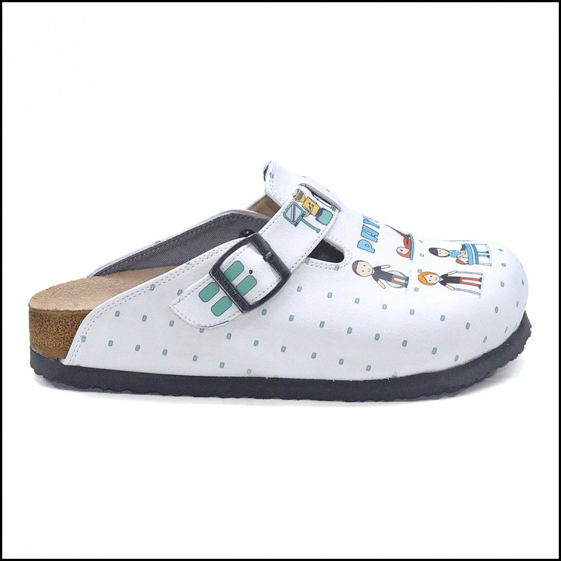 May include: White leather clog with a green and blue patterned design. The clog has a cork sole and a black buckle. The design features a family of stick figures with the text "Pati" on the shoe.