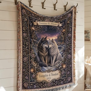 Peut inclure: Un plaid tissé représentant deux loups assis ensemble dans une forêt la nuit. Le motif comprend une bannière avec le texte Forever & Always et une plaque inférieure avec les noms Evangeline & Theodore et l'année 2024, entourés de bordures florales.