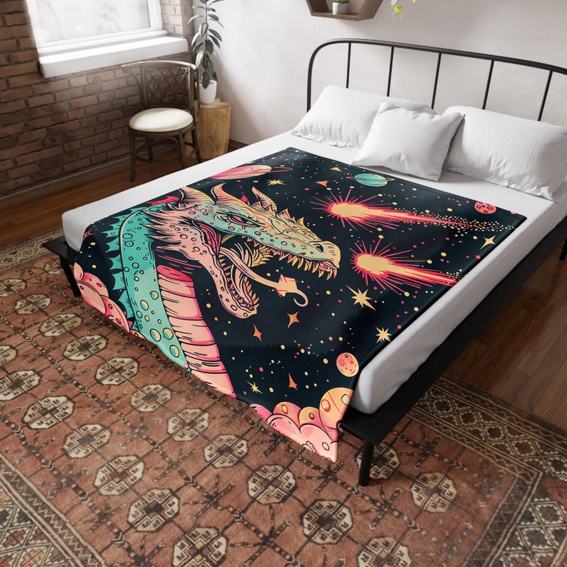 May include: A colorful throw blanket with a dragon design and a galaxy background. The dragon is breathing fire and there are stars and planets in the background.