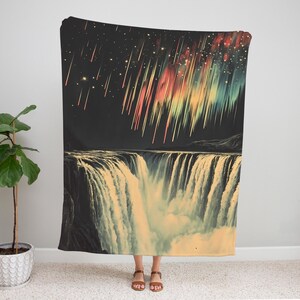 May include: A colorful tapestry featuring a waterfall with a night sky background. The sky is filled with stars and streaks of light in shades of red, yellow, green, and blue.