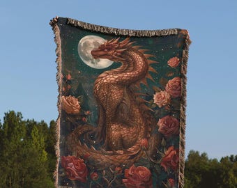 Puede incluir: Un tapiz tejido con un dragón dorado con rosas rojas y una luna llena en el fondo. El tapiz está sostenido por una persona frente a un cielo azul y árboles verdes. El texto "the cool ruler.co" está en la parte inferior de la imagen.
