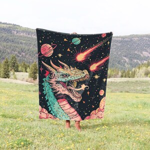 May include: A black tapestry with a colorful dragon head and shooting stars. The dragon has green, pink, and blue scales. The background is a dark blue with white stars.