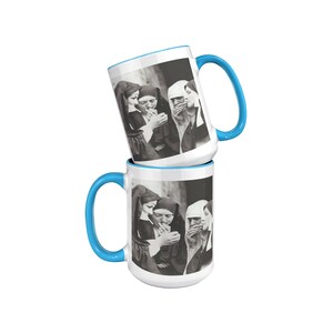 May include: Two white ceramic mugs with blue rims, each featuring a black and white photo of three nuns smoking cigarettes. The mugs are stacked on top of each other.