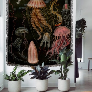 May include: A tapestry featuring a vintage illustration of various jellyfish in shades of pink, red, yellow, and white against a dark green background.