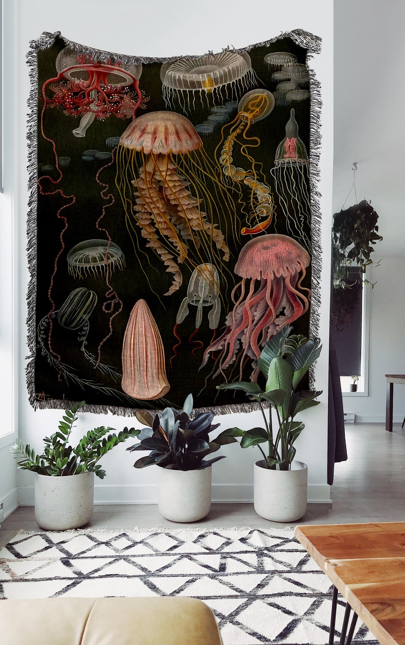 May include: A tapestry featuring a vintage illustration of various jellyfish in shades of pink, red, yellow, and white against a dark green background.