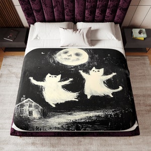 May include: A black and white illustration of two white cats flying in the air with their arms outstretched. The cats are flying in front of a large, white moon with a skull face. A small house with a lit window is in the bottom left corner of the image.