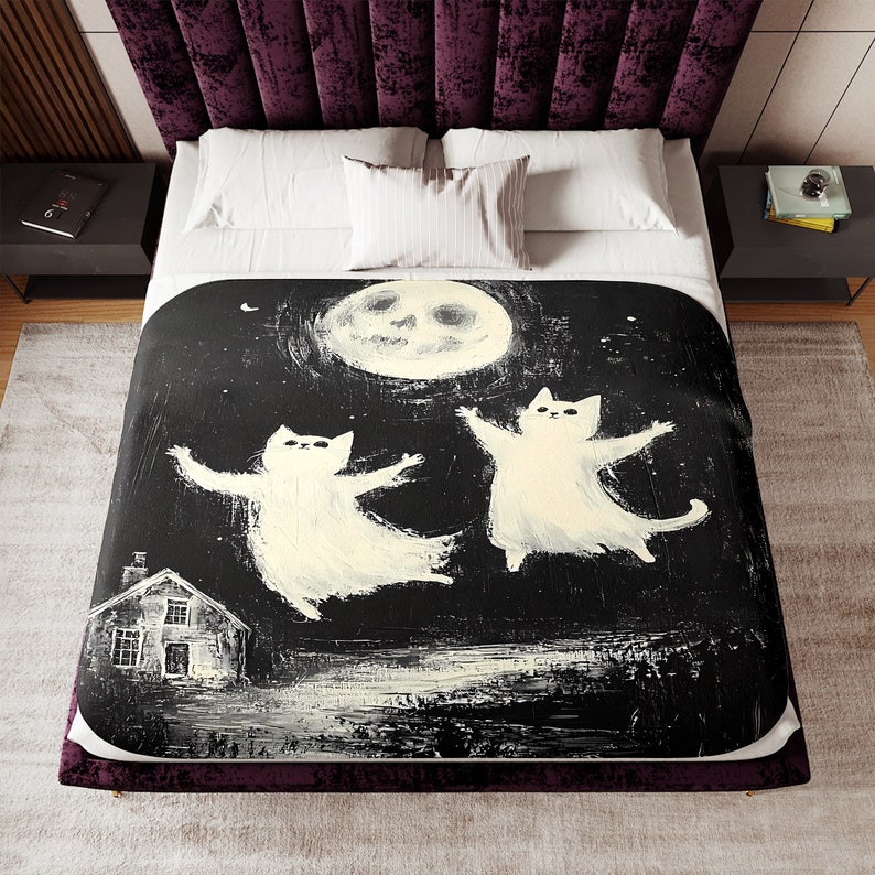 May include: A black and white illustration of two white cats flying in the air with their arms outstretched. The cats are flying in front of a large, white moon with a skull face. A small house with a lit window is in the bottom left corner of the image.