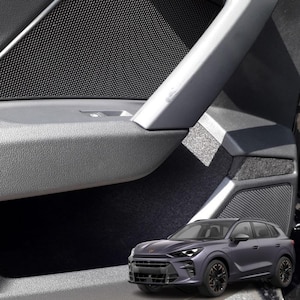 May include: A car door interior with a dark grey textured panel and a silver handle. The door has a speaker grill and a window control button. A dark grey SUV is in the foreground.