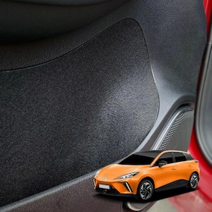 Puede incluir: Primer plano de un panel de puerta de coche negro con superficie texturizada. Un coche naranja, modelo hatchback, se muestra en primer plano, con detalles y ruedas negras.
