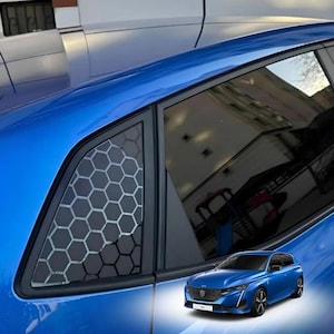 Puede incluir: Un coche azul con un tinte de ventana de panal de abeja negro. El coche tiene un borde negro alrededor de las ventanas y un alerón trasero negro. El coche está aparcado en un garaje.