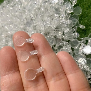 May include: Three clear plastic round targets with a small loop on top. The targets are different sizes and are held in a hand.