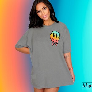 May include: Gray oversized t-shirt with a colorful dripping smiley face graphic on the front.  "AZandADDI - DESIGNS" is printed on the bottom right corner of the image.
