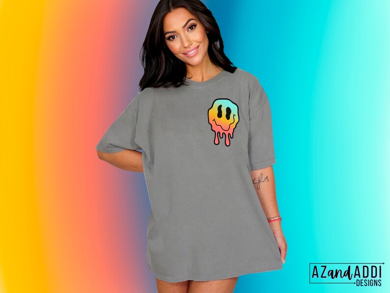 May include: Gray oversized t-shirt with a colorful dripping smiley face graphic on the front.  "AZandADDI - DESIGNS" is printed on the bottom right corner of the image.