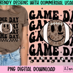 May include: Brown t-shirt with a "Game Day" design. The design features a football with a smiling face and leopard print. The text "Game Day" is repeated multiple times in a retro font. The image also includes the text "PNG DIGITAL DOWNLOAD".
