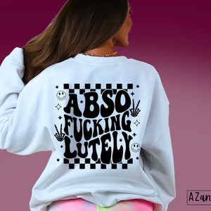 May include: White sweatshirt with a black graphic print that says "Abso Fucking Lutely" in a retro font. The graphic also includes a checkered pattern, smiley faces, and peace signs.