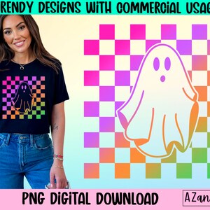 Op de afbeelding: Zwart T-shirt met een spookafbeelding op een geruite achtergrond in roze, oranje en groene tinten. De tekst "TRENDY DESIGNS WITH COMMERCIAL USAGE" en "PNG DIGITAL DOWNLOAD" staan bovenaan en onderaan de afbeelding.